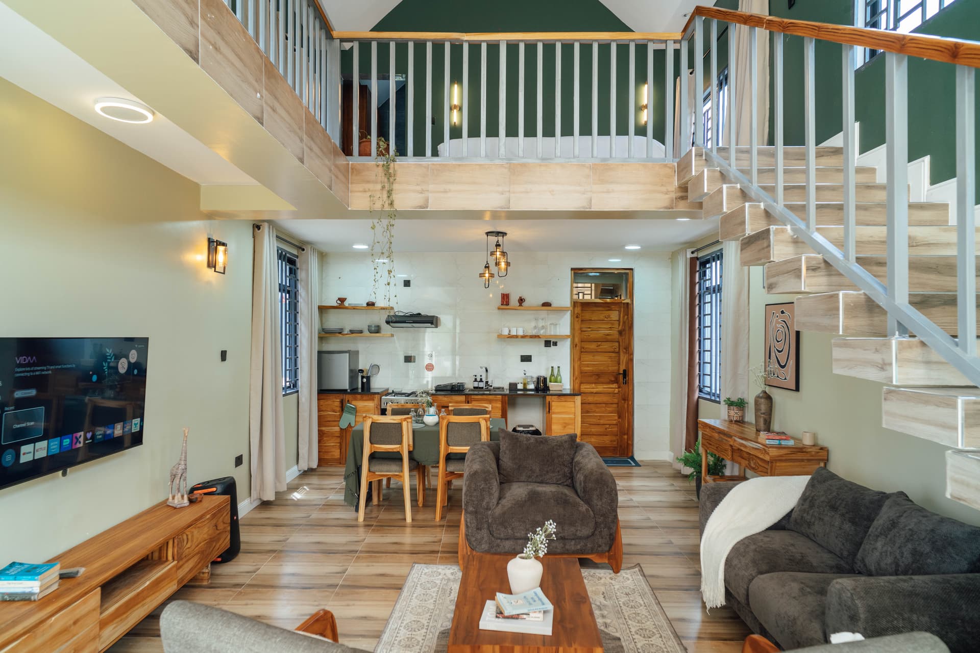 Acacia Loft living room with mezzanine bedroom above and full kitchen at Starico Residence