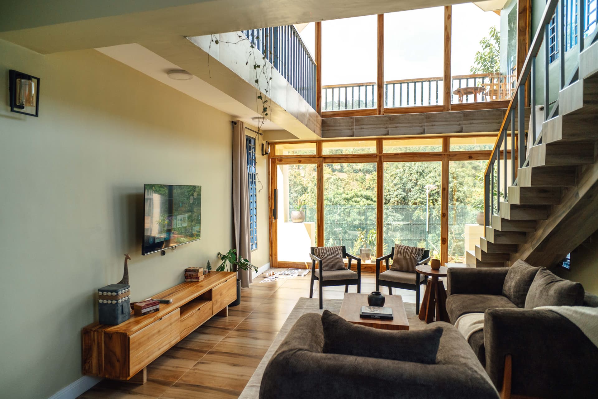 Savanna Loft double-height living room with floor-to-ceiling windows over Moivaro hills